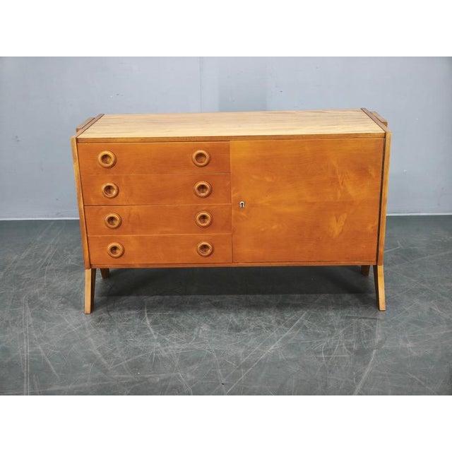 A refined mid-century sideboard produced in Czechoslovakia in the 1960s, featuring a warm maple veneer finish and a clean,...