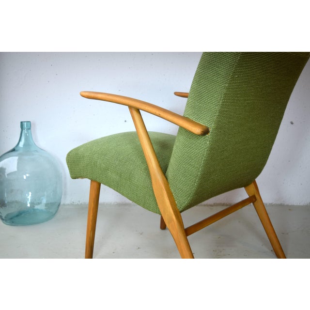 This is a green lounge chair from the 1950s. The chair features classic upholstery made of iron springs and natural...