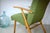 This is a green lounge chair from the 1950s. The chair features classic upholstery made of iron springs and natural...