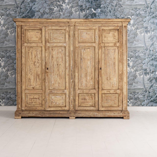 An Italian cabinet from the 18th century in original aged ochre paint. Two large, full length doors open to 8 fixed...