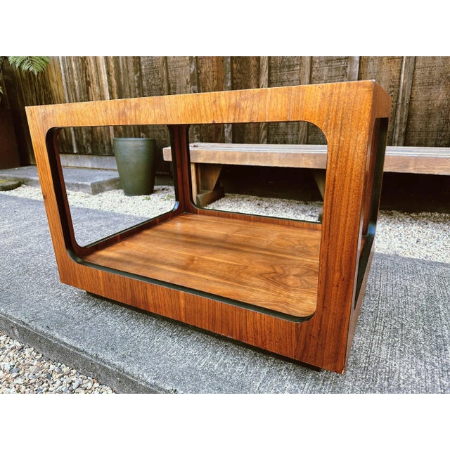 Smoke glass table top inset to stunning walnut veneer clad base creates a seamless look. Second tier beautifully finished...
