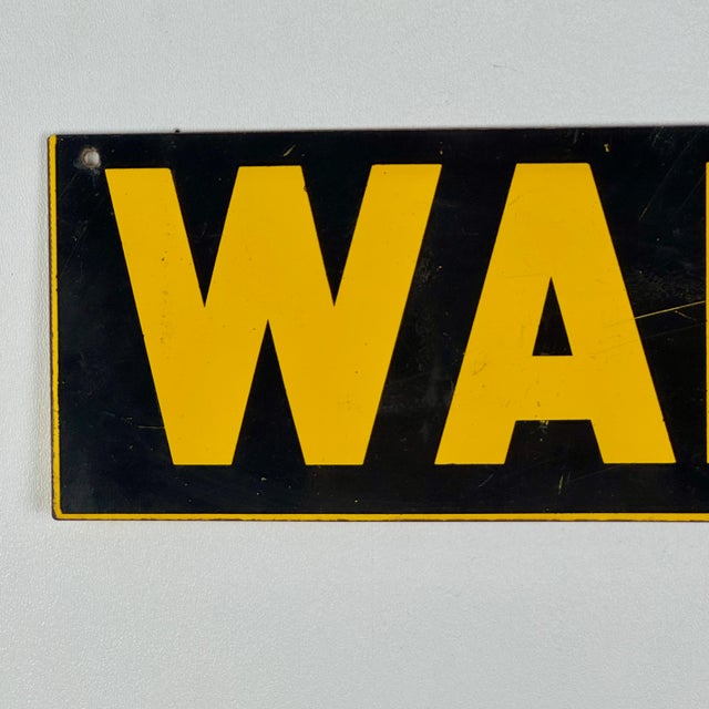 A metal and enamel sign stating: "WARNING". It's in a gorgeous school bus yellow against black. 3 holes at the top for...