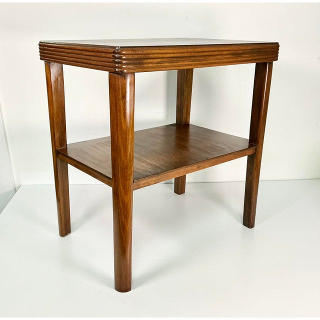 This is a lovely Art Deco Side Accent Table from the 1930s. Crafted from wood, it features a lower shelf for storage and...