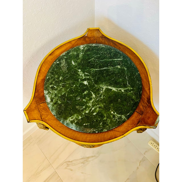 Two unique marble-top Pedastals. The color of the marble on the top is green. Bronze in-lay figures adorn the sides....
