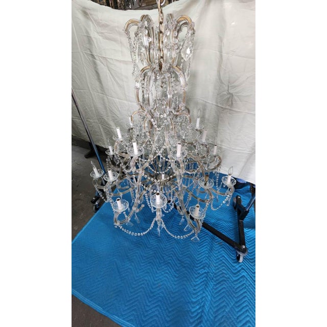 This listing features a large crystal chandelier with intricate details such as beading and hand-carved crystal pendants....