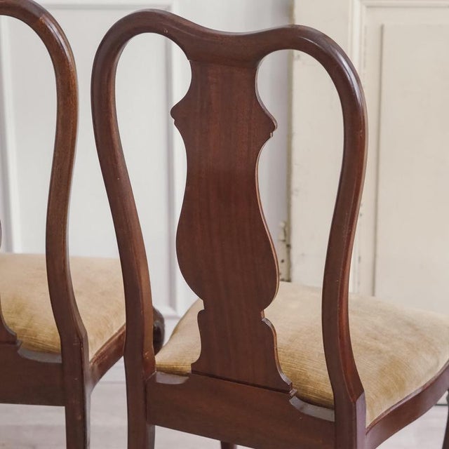 A set of four high-backed chairs in the Queen Anne style, dating from around 1890, with a vase-shaped crossbar and...