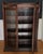 Carved oak vitrine from the turn of the twentieth century, bridging late Victorian ornament and the discipline of the Arts...