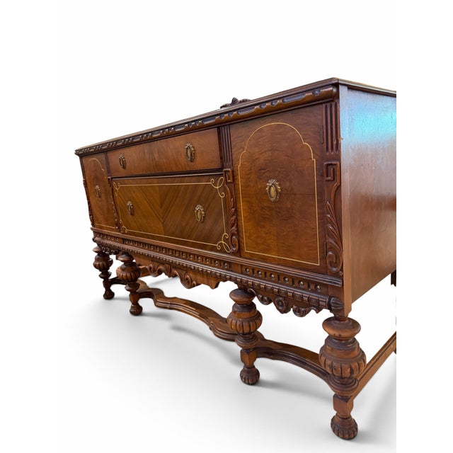 Add grand architectural presence to your dining room with this magnificent 1920s Jacobean Revival sideboard. Crafted from...