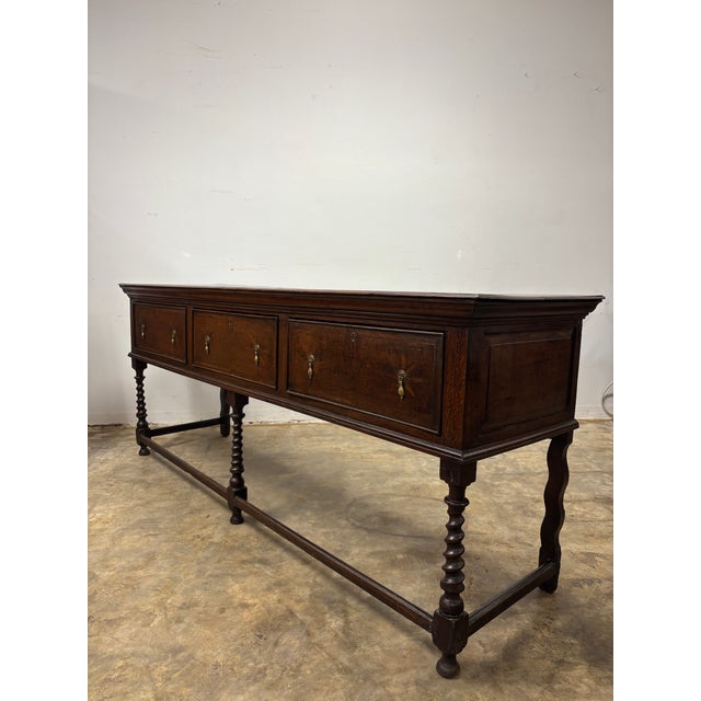 Some pieces of furniture reveal themselves slowly. From across the room, this antique English oak sideboard impresses...