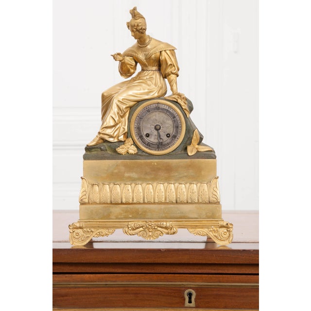 This beautifully detailed Napoleon III fire-gilt bronze figural mantel clock is from France, circa 1860-1880. Featuring a...