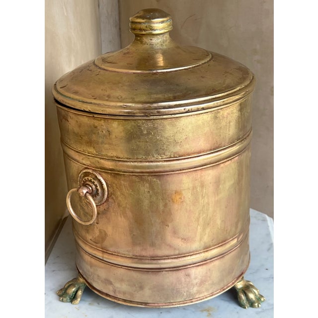 19th century brass coal bucket with three brass lion feet, a metal insert and lid. The handles are mismatched as one was...