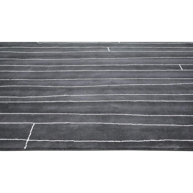 Moroccan hand knotted wool rug with abstract design.