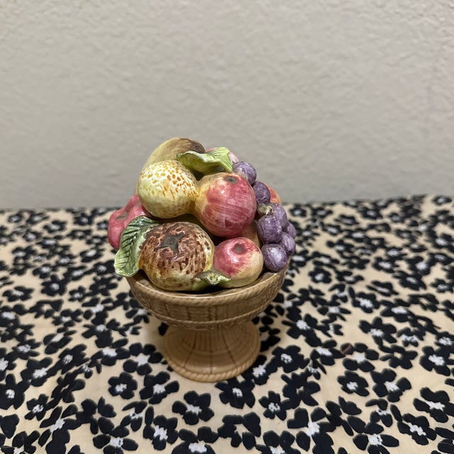 A charming vintage Italian Majolica centerpiece featuring a vibrant, hand-sculpted arrangement of pome fruits and purple...