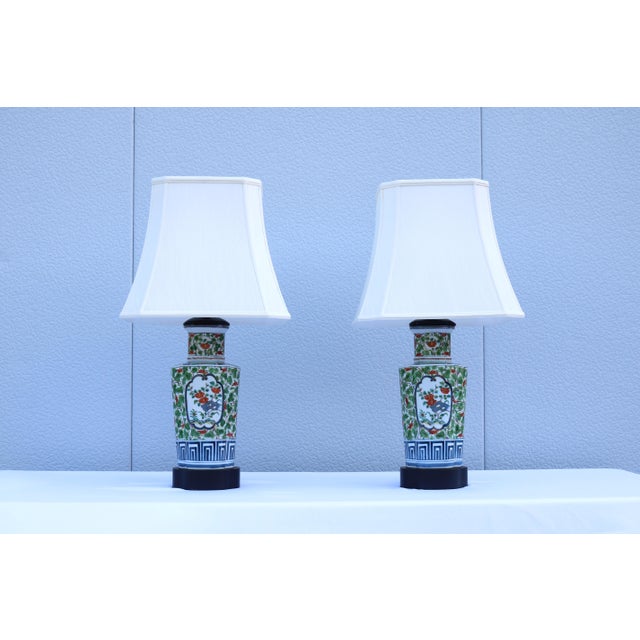 Fabulous matching pair of vintage Chinese floral porcelain table lamps designed in the vibrant Famille Verte (green...