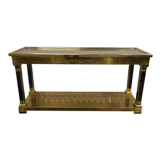 Offered is a rare neoclassical style brass console table Mastercraft. This stately piece features an inset beveled glass...