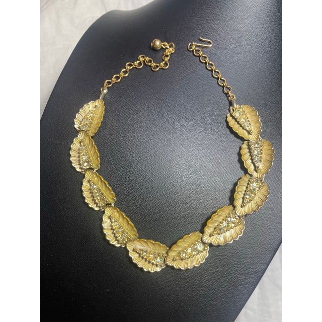 MCM choker necklace by BSK is designed with articulated leaf-shaped links in a warm, textured gold-tone finish. Each...