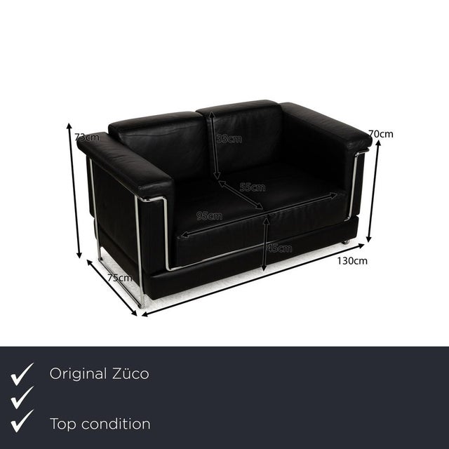 The two-seater Carat from Züco is covered in black leather and stands on narrow metal runners. The individual upholstered...