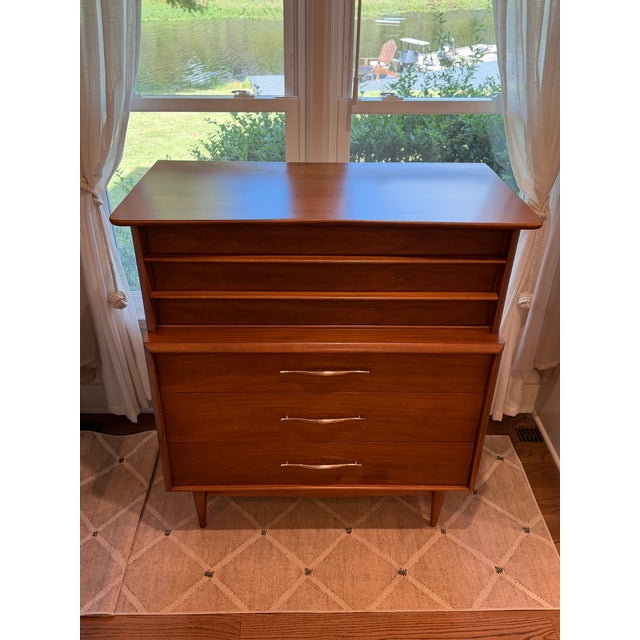 Warm wood grain and beautifully sculpted drawer fronts give this authentic Kent-Coffey “Foreteller” dresser unmistakable...