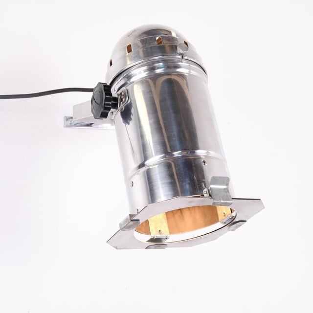 Vintage spotlight / theatre lamp from the 1950s, made of polished aluminium. The lamp features an adjustable mounting...