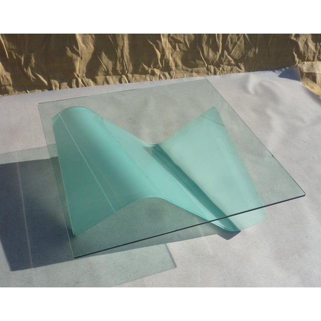 Coffee table with a frosted glass "sail" base supporting a clear, square glass top 12 mm thick. The design is attributed...