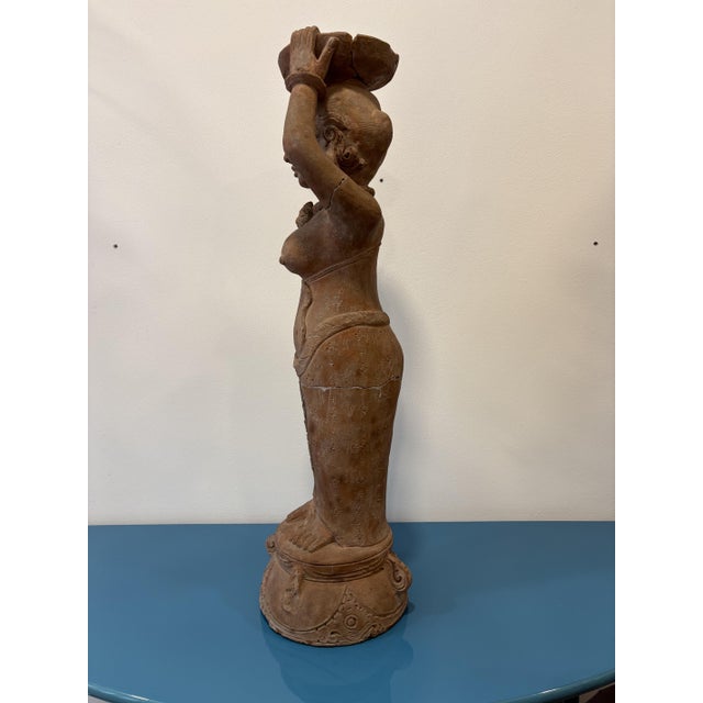 A terracotta figure depicting a maidservant from the 15th-century Majapahit Empire. These figures were often kept in homes...
