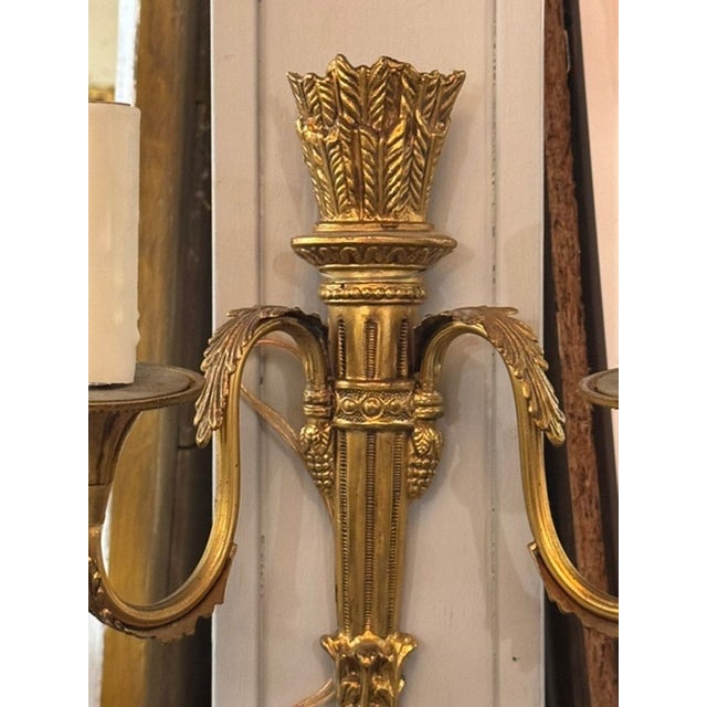 The product is a pair of French Empire gilt bronze sconces, featuring a handsome classic design Made with luxurious...