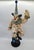 A striking, large decorative figure depicting a circus clown riding a unicycle, created by jun asilo. The sculpture is...