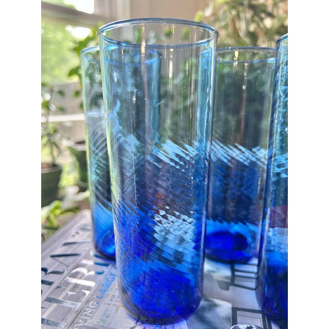 A beautifull set of four vintage hand-blown highball glasses in a rich cobalt blue ombré, each featuring a subtle optic...