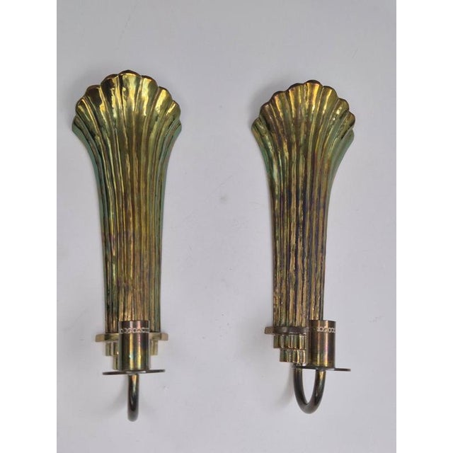 A pair of decorative shell shaped candle sconces in solid brass by Lars Holmström, Arvika, Swedish Modern 1940s. A simple...