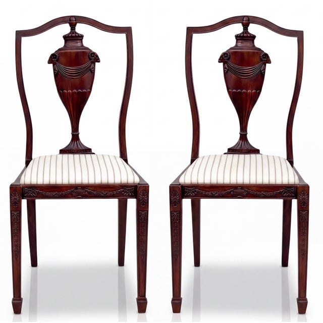 This is a pair of carved mahogany neo-classical style side chairs. The backs are carved urns with ram form accents. The...