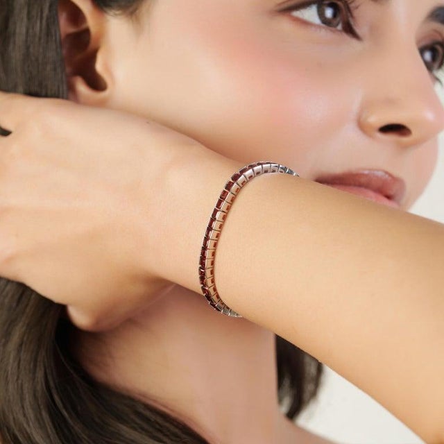 Crafted in 925 sterling silver, this elegant natural garnet tennis bracelet features 58 square-cut garnet gemstones, each...