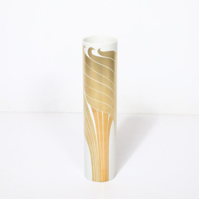 This elegant Rosenthal Mid-Century Porcelain Cylindrical Vase w/ 24Karat Gold Overlay originated in Germany, circa 1980. A...