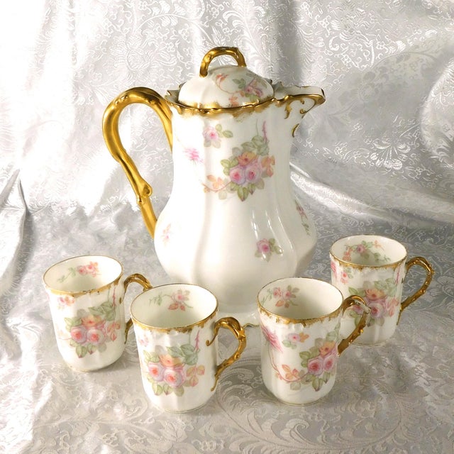 This is a Limoges chocolate pot with four matching cups. The pot and cups have two backstamps-an Elite Limoges backstamp...
