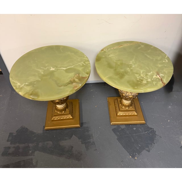Striking pair of vintage side tables featuring round translucent green onyx tops with beautiful natural veining and warm...