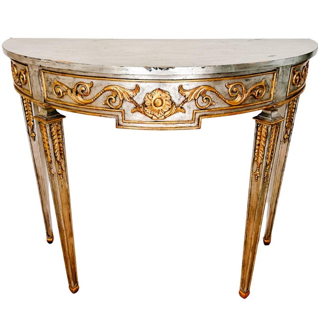 A sophisticated demilune console table by Maitland-Smith, featuring a Neoclassical silhouette and hand-applied distressed...
