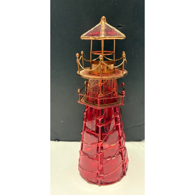 Vintage Red Glass Lighthouse Candle Holder Charming lighthouse-style décor piece featuring deep ruby red glass panels and...