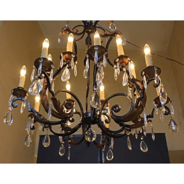 Late 19th century French iron & crystal 15-light chandelier. 2-tiers in an unusual configuration moving from a tight body...