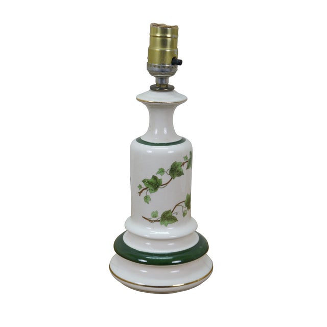 Mid to late 20th century white porcelain table lamp with green accents and litho printed ivy vine design. Includes brass...