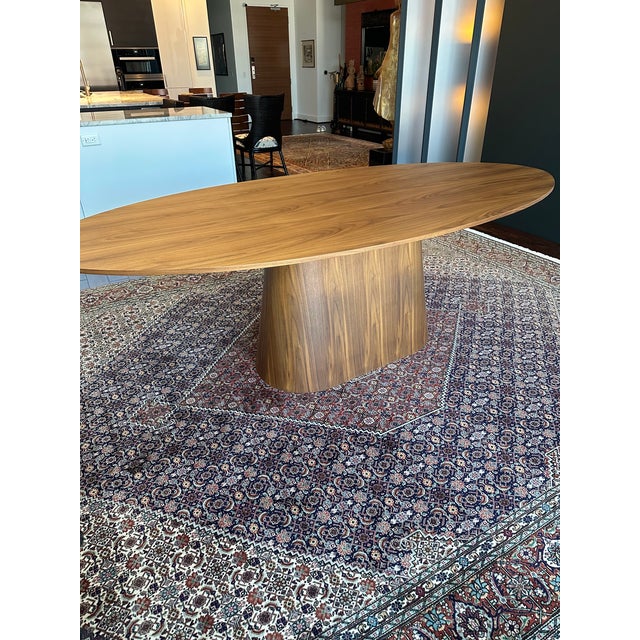 Oval Dining Table Made of Composite Wood and Walnut Natural Wood Veneer. Comfortably seats up to 8 guests.