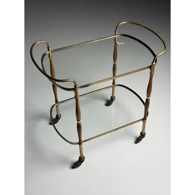 Italian mid-century serving trolley/bar cart. from the mid-20th century. with two glass shelves. Rolls well. In very good...