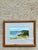 This vintage framed coastal landscape painting captures the peaceful beauty of the shoreline through a harmonious...