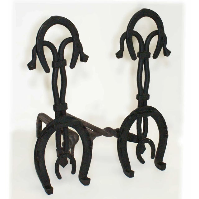 Pair of early 20th century folk art style andirons. Wrought iron incorporating horse shoes.