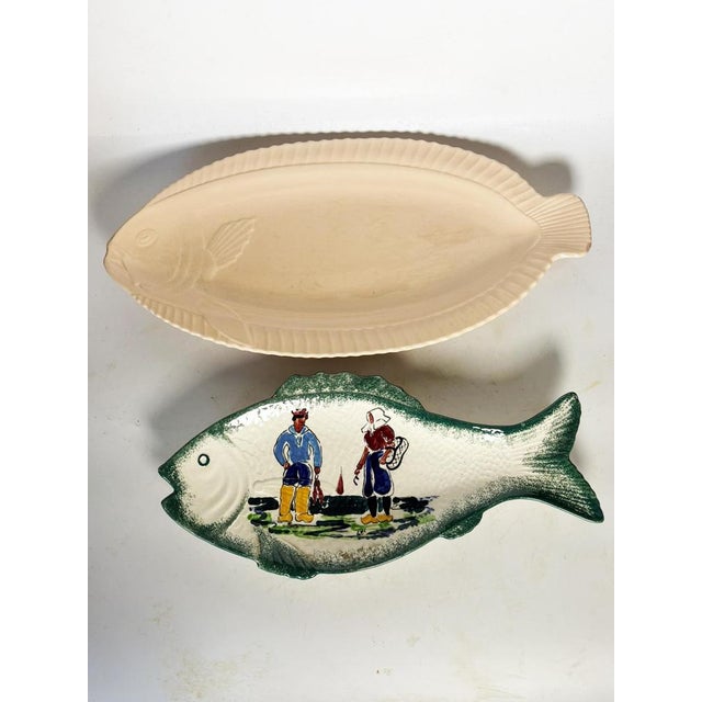 Set of two ceramic fish-shaped dishes, France, 1970s. This decorative and functional duo comprises: - a large cream-...