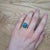 A Sonoran turquoise shines in a robin's-egg blue at the heart of this solid 14K yellow gold ring, framed by forty-eight...