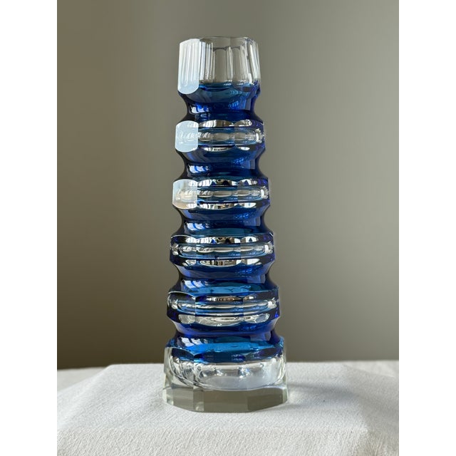 An octagonal Art Deco vase made of cut glass. A tall vase of layered blue and clear glass in the style of Carl Meltzer, of...