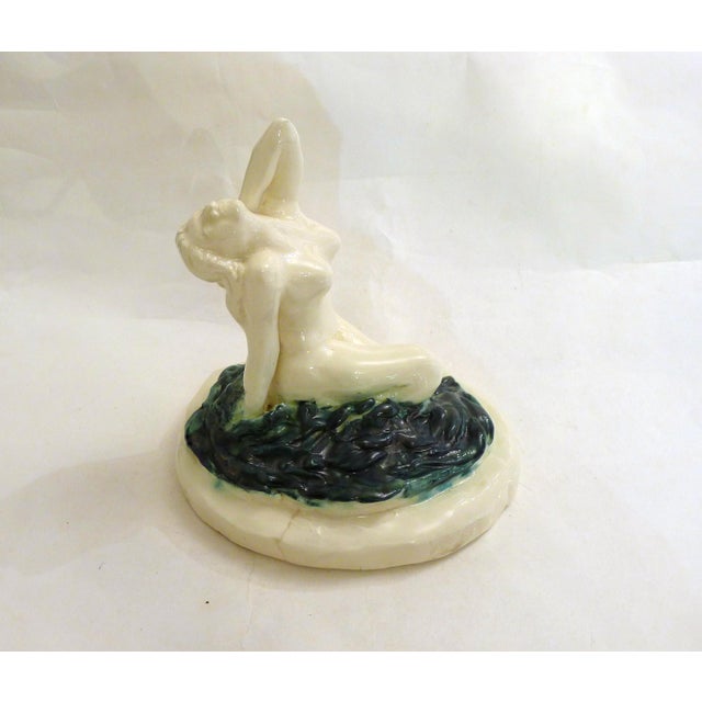 Mid-century sculpture of a bather. Oval base with rough reliefs and striated volumes representing stylized waves; upon...
