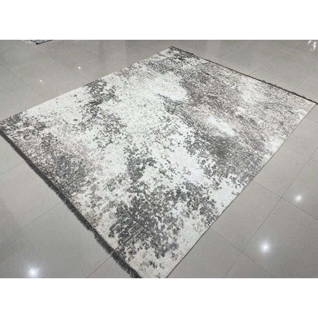 This hand knotted pile rug features a primary color palette of ivory, beige, cream, and white. Crafted from wool, it...