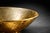 A striking vintage gold art glass pedestal bowl featuring a sculptural, shallow conical form and textured metallic finish....