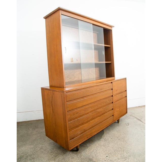 3 drawer china cabinet in an American 1960s styling. Each of the drawers slide in to the rest of the piece to create clean...