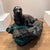 Sea-lion atop a rock island. Made from earthenware it’s quite heavy. Beautiful glassy deep green glazing.